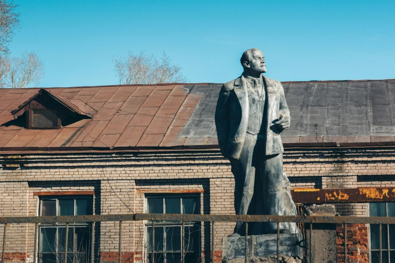 a brick building with a large stone statue in front of it