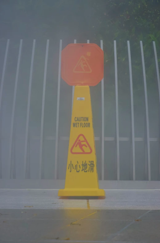 a yellow caution wet floor cone is on the ground