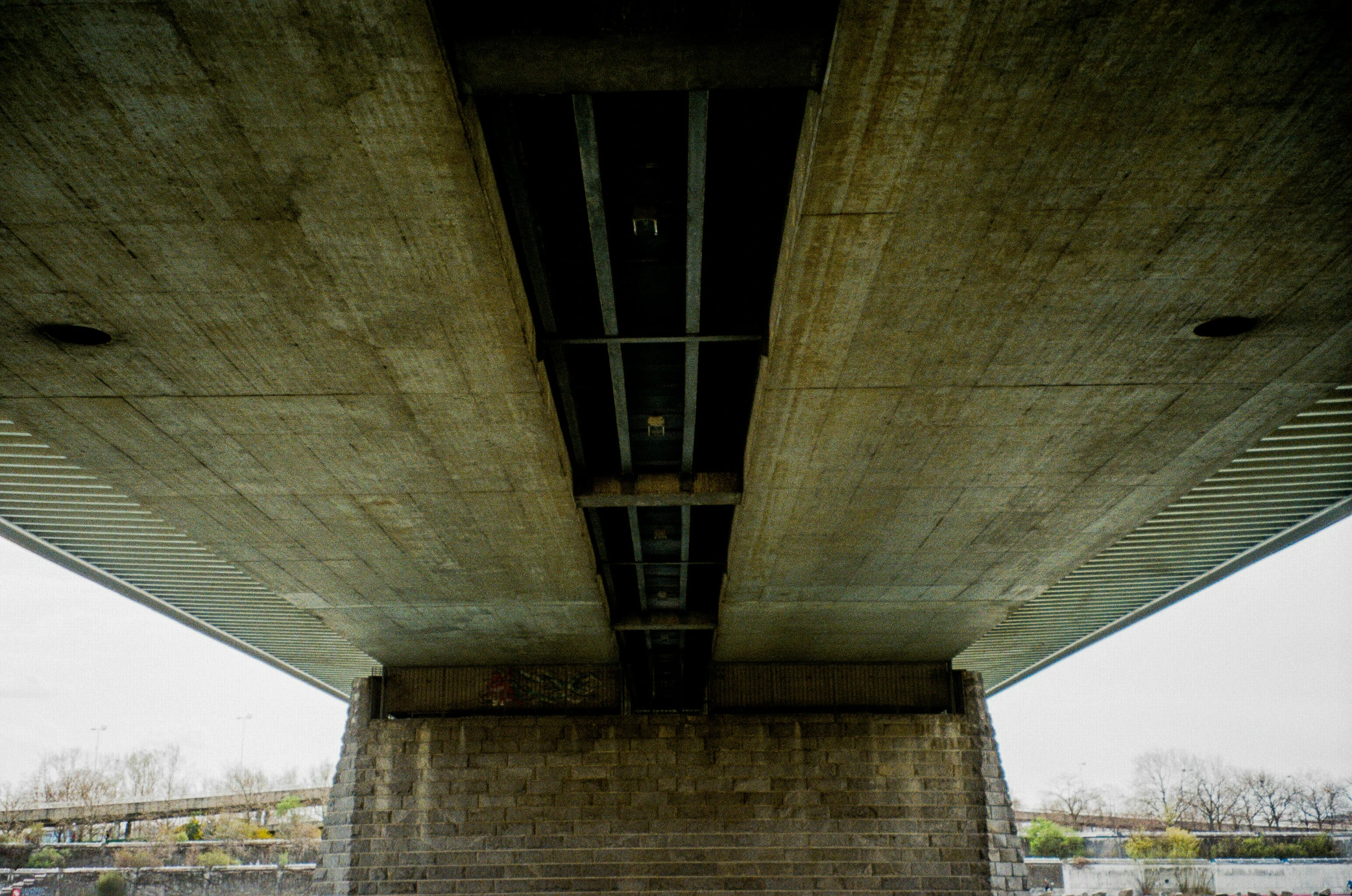 people are walking under a bridge with stairs