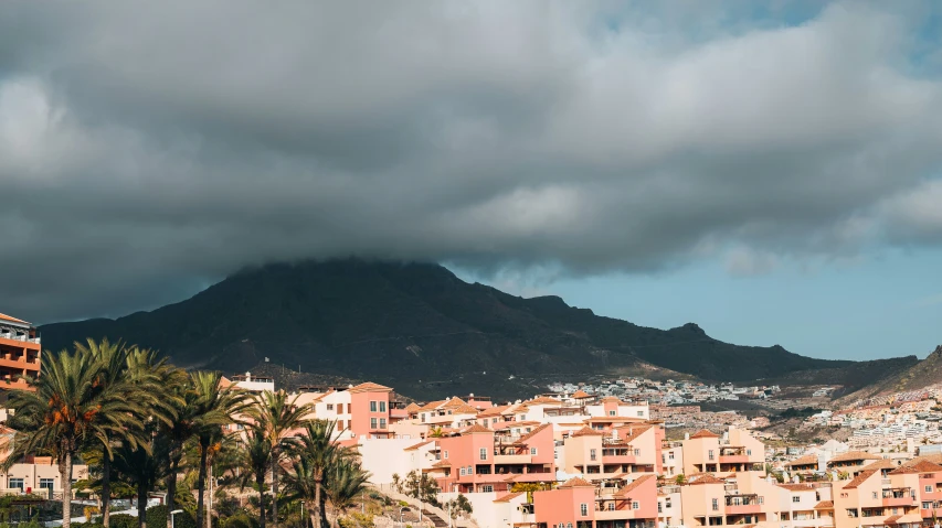 a mountain sits in the background behind many buildings