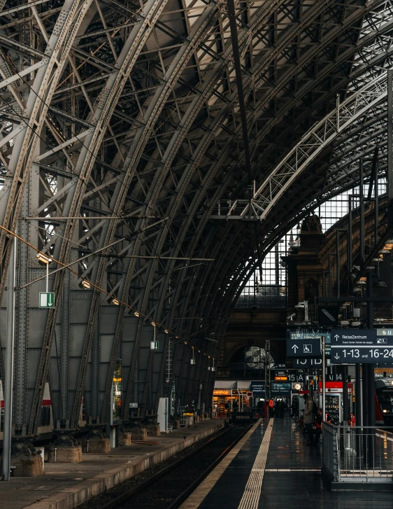 inside of a large train station with multiple tracks and overhead platforms