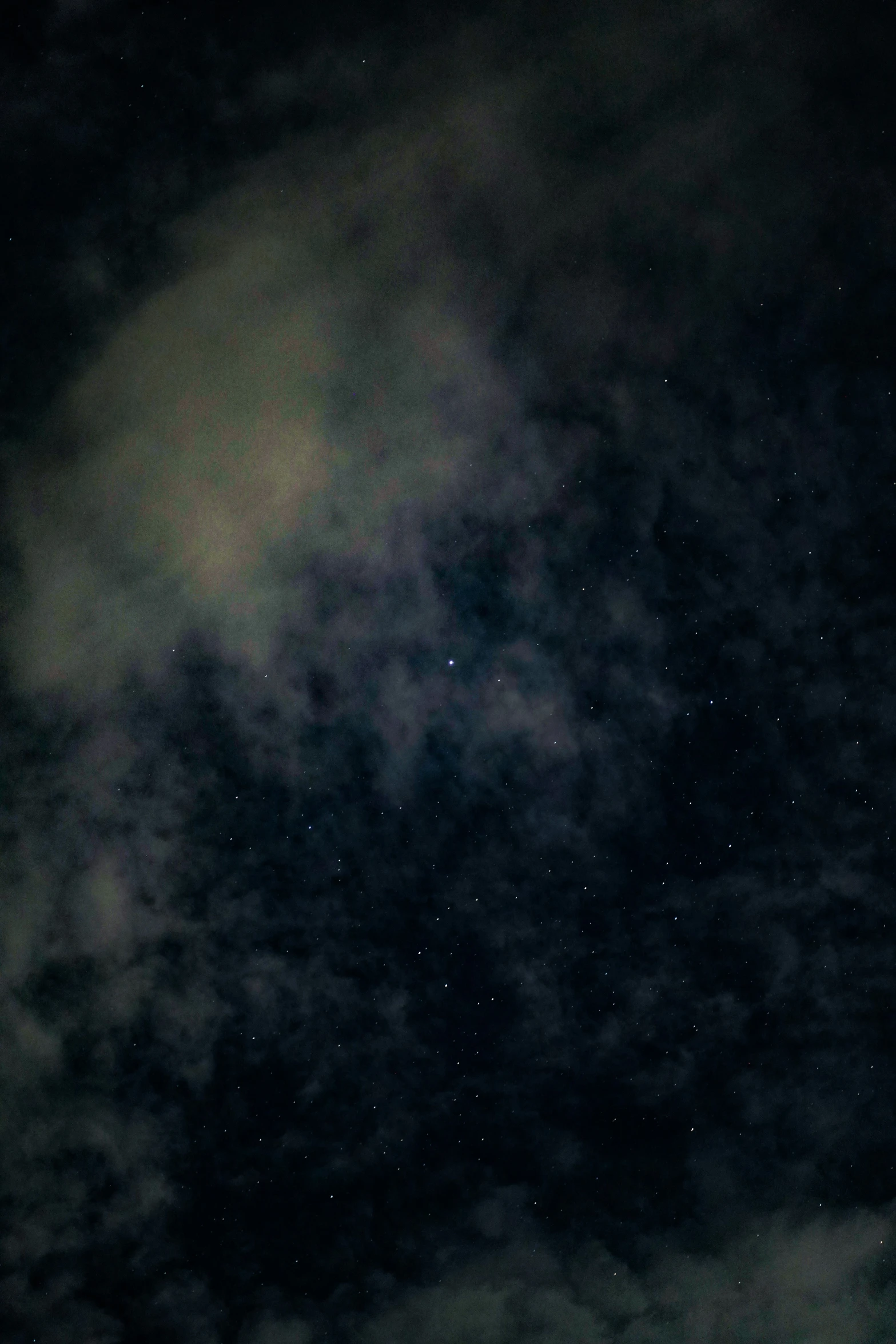 the top of some clouds on a dark sky with stars