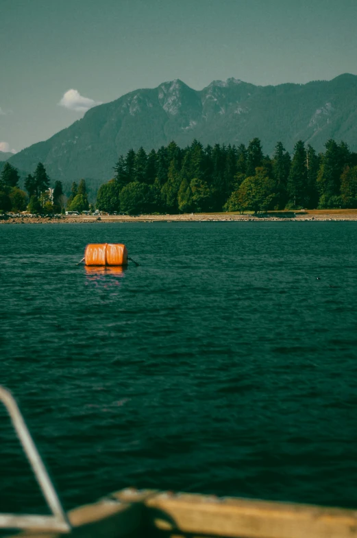 the orange buoy floats in front of the mountain range