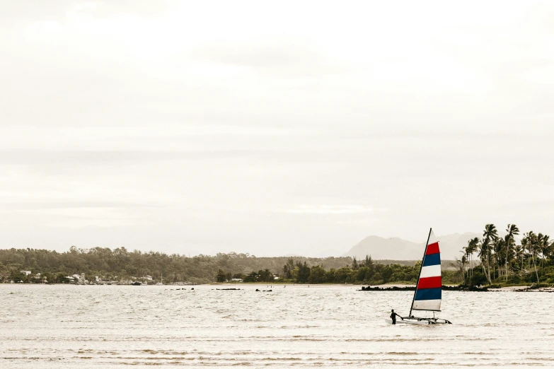 a small boat on water with trees in the background