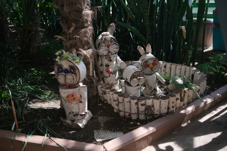 three rabbits sculptures sitting in the center of a garden