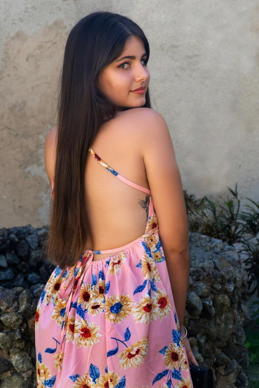 a girl in a flowered dress is standing