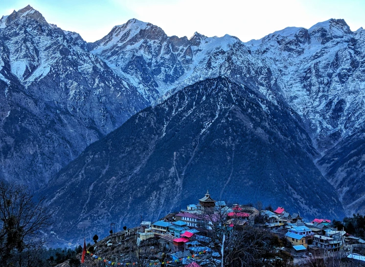 the snowy mountains with some colorful buildings below