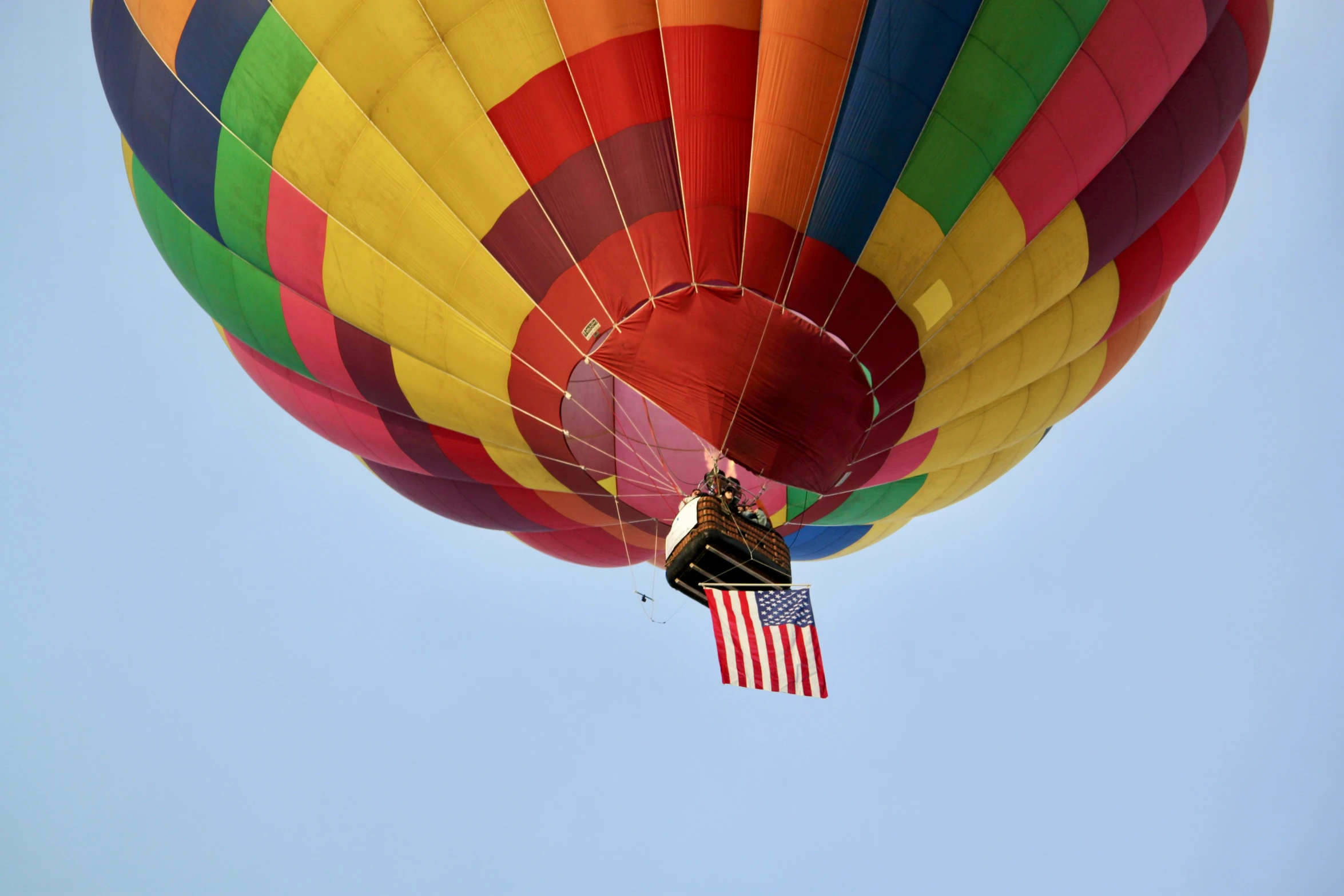 a multi colored  air balloon flying through the sky