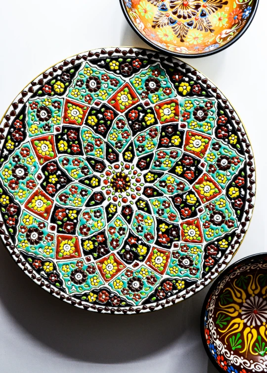 decorative, patterned serving plates sit next to a painted dish