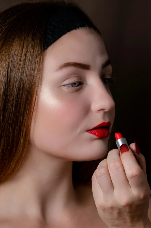 the woman is dressed with red lipstick, wearing black headband