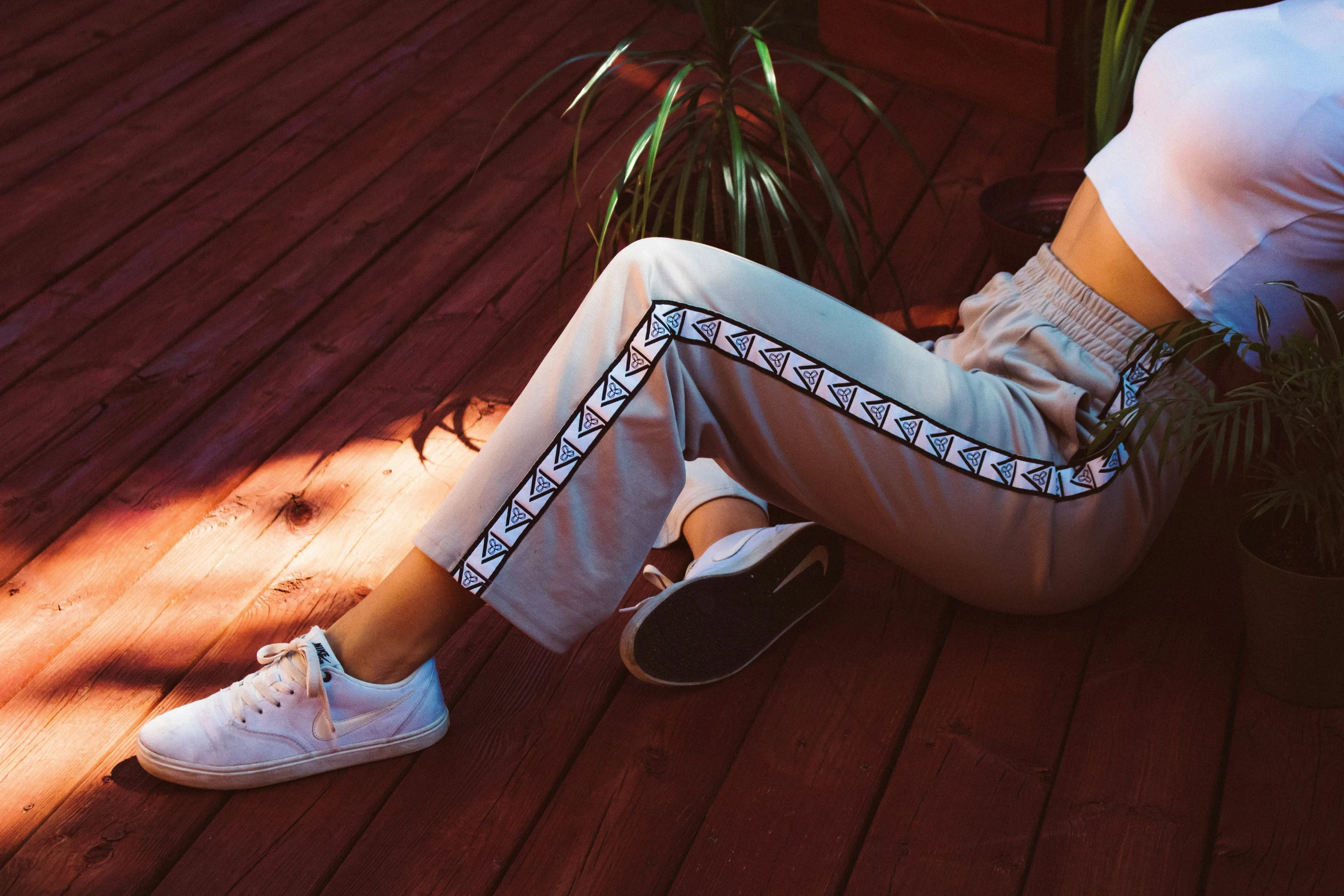 a woman sitting on the floor next to plants