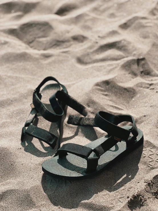 a pair of sandals resting on the sand