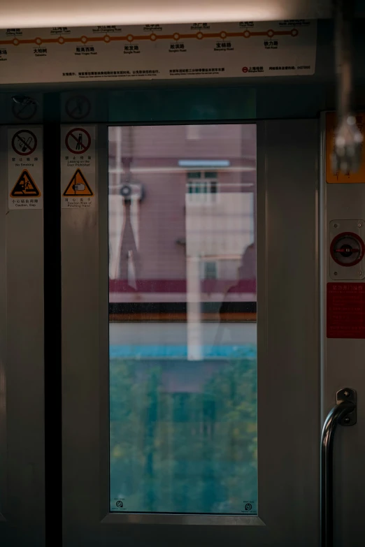 a window looking out onto a building next to a train