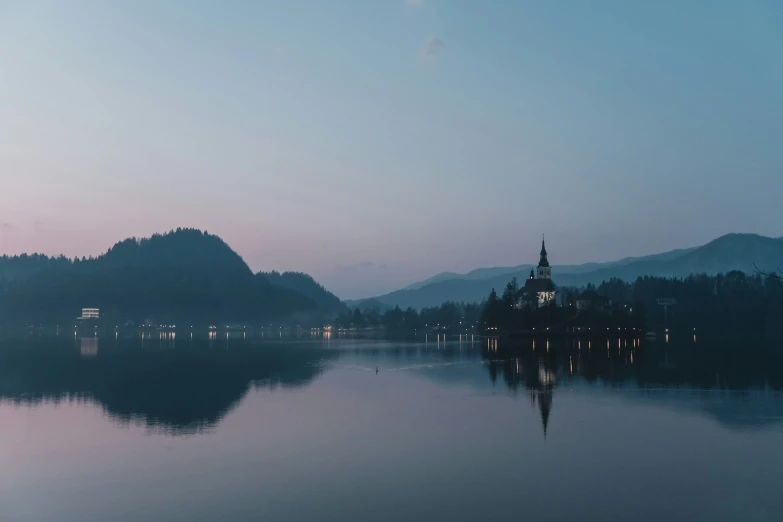 a view of some mountains and a lake during sunset