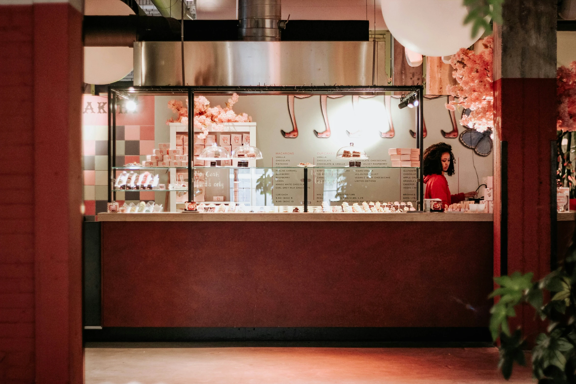 an empty red and black bar in a restaurant with a person behind it