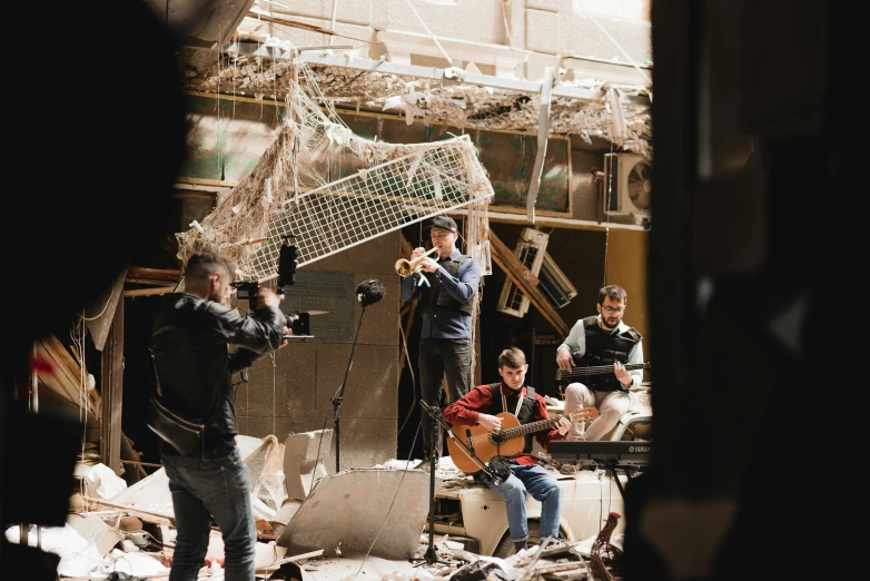 a group of men with guitars sitting on some rubble