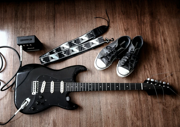 two guitars are laid on the floor beside some headphones