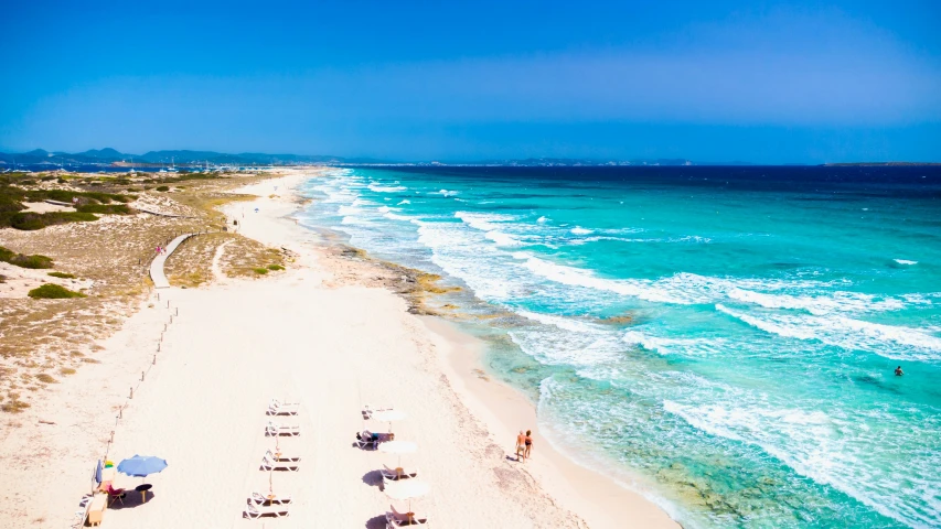 an empty beach filled with umbrellas and white sand