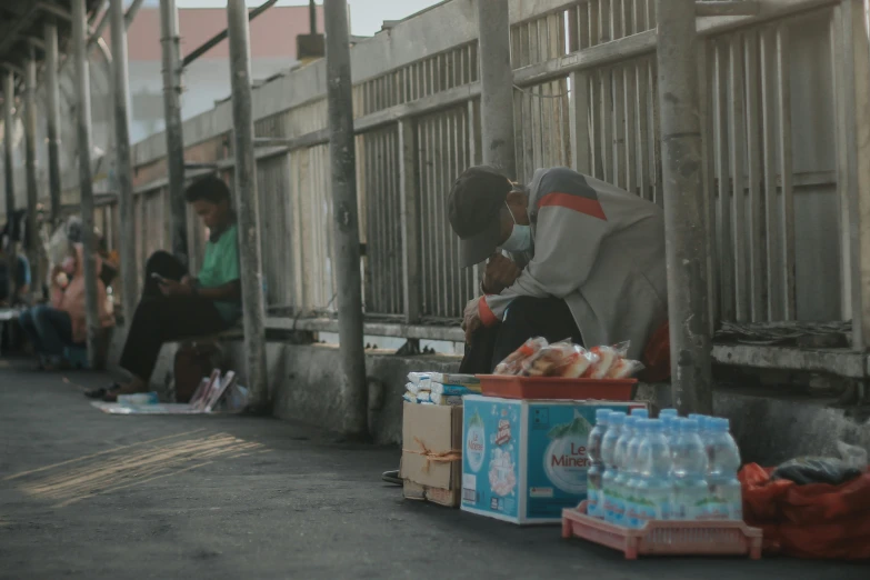 there are people and crates of water by the side of the street