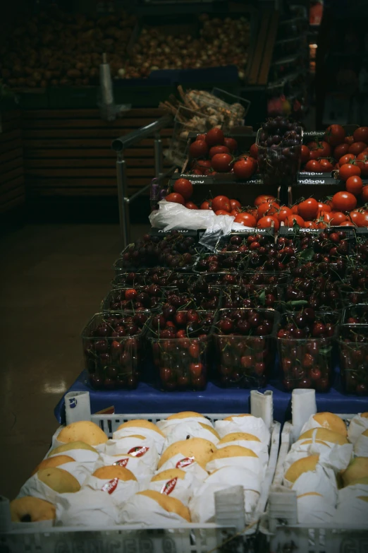 tomatoes and other fruits are stacked in plastic bins