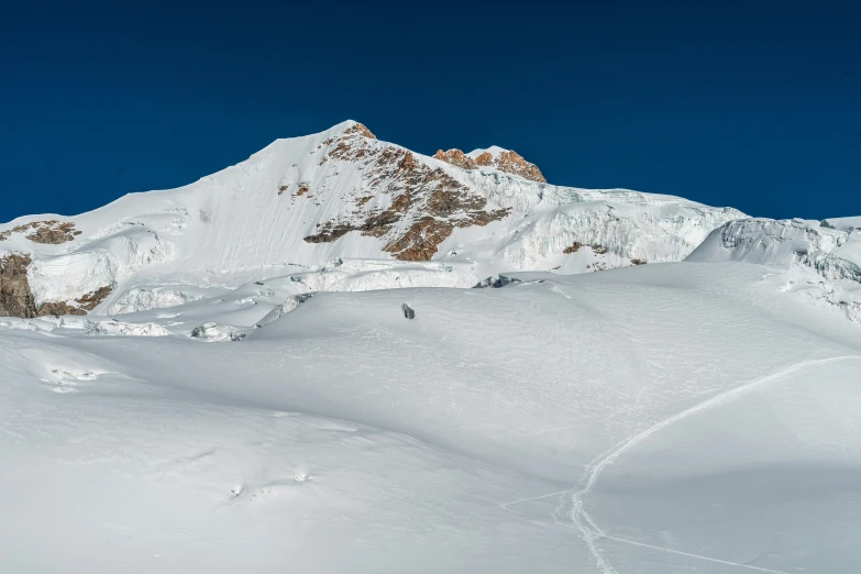 a man riding a skii down the side of a snow covered slope