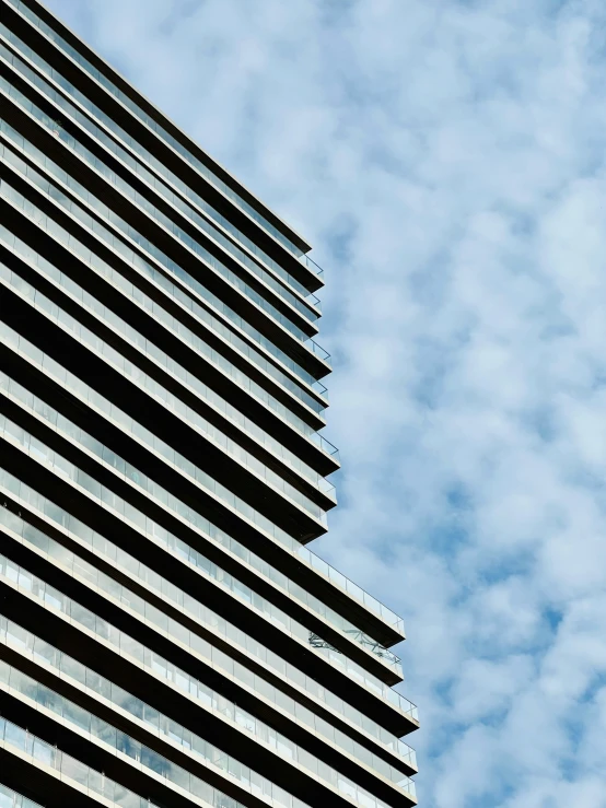 a tall building sitting under a cloudy blue sky