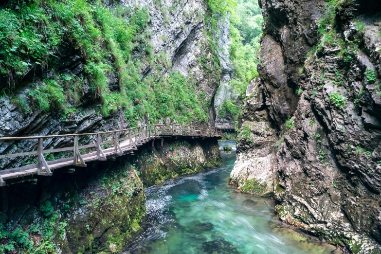 a small bridge across a river in a canyon