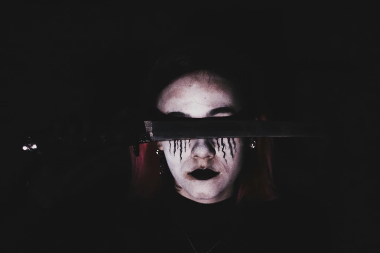 a woman with makeup on her face looking through a knife