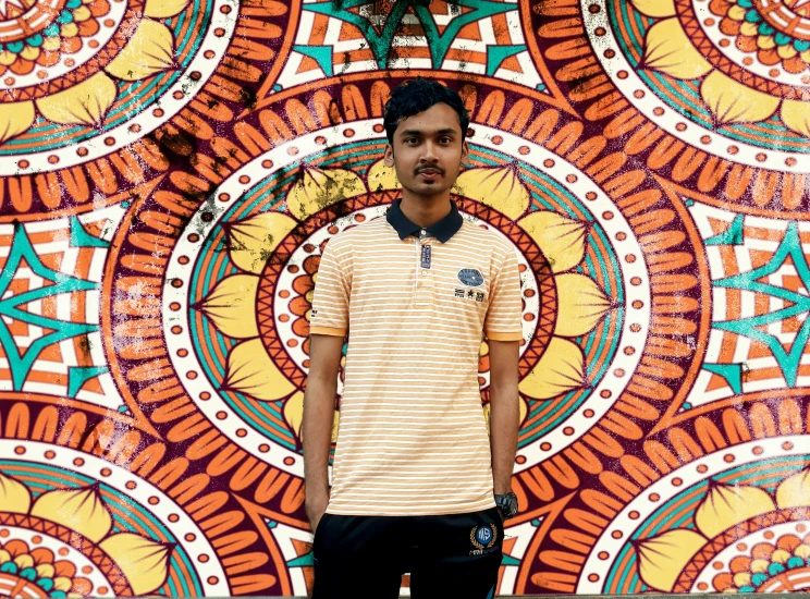 a man standing in front of a big colorful wall