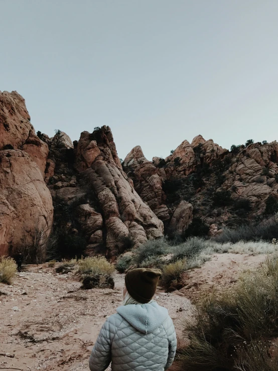 a man standing alone in the desert surrounded by tall mountains