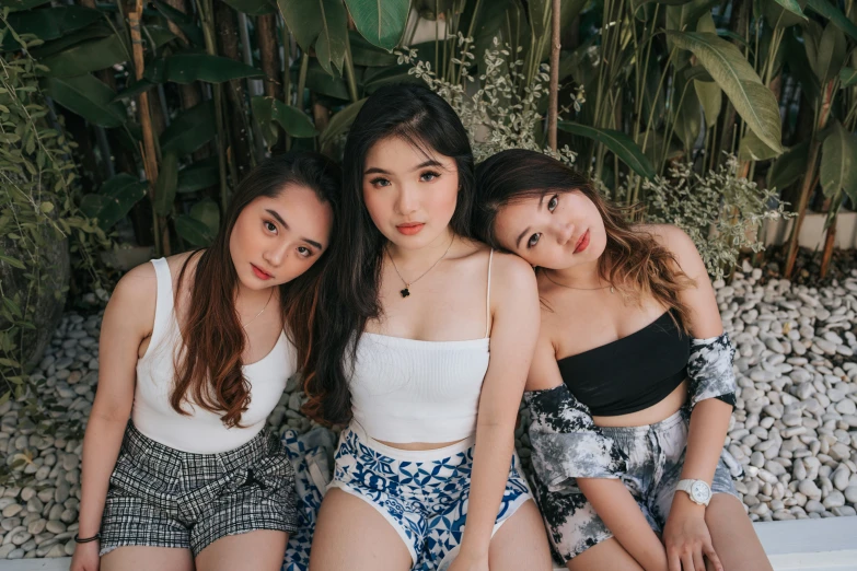 three pretty girls in short shorts sitting next to each other