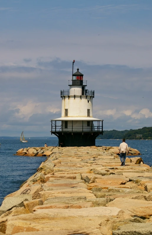 a large light house sitting on top of a rocky pier