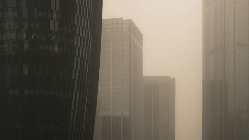 a foggy, city street with multiple tall buildings