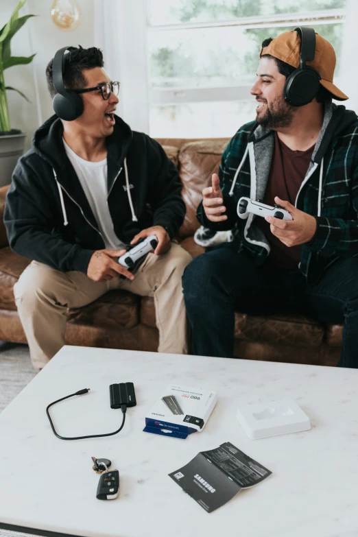 a couple of men sitting next to each other on top of a couch