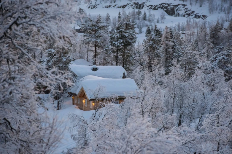 the top view of a snowy mountaintop with a cabin in it