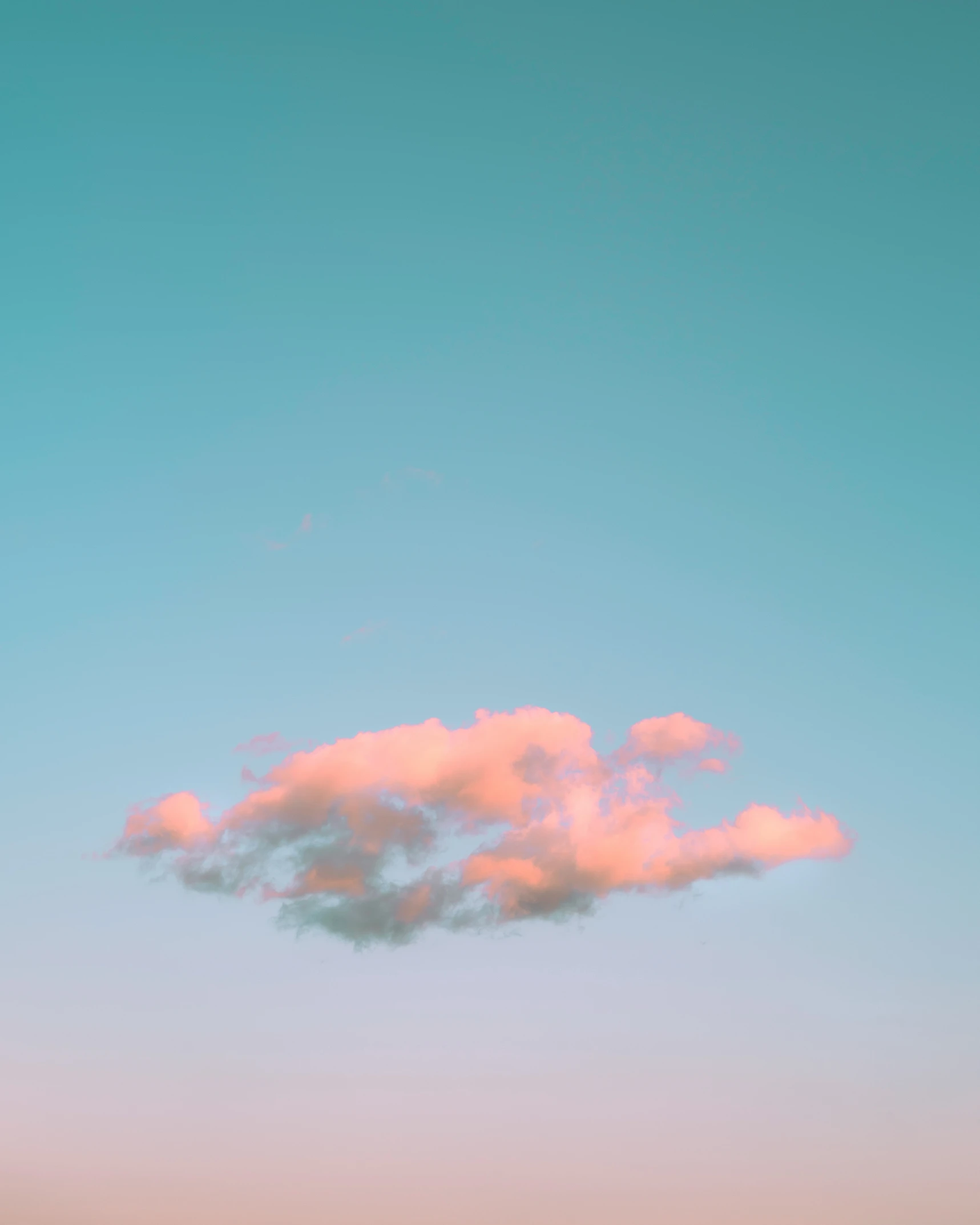 a plane flies through the air behind some pink clouds