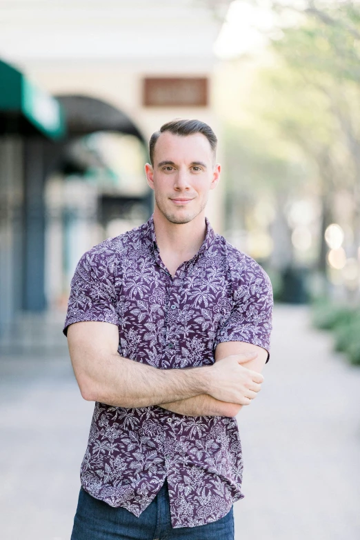 a man wearing a purple shirt and standing on the sidewalk