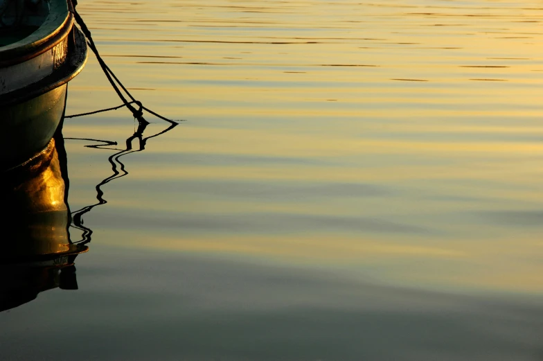 a boat is sitting in the water at sunrise