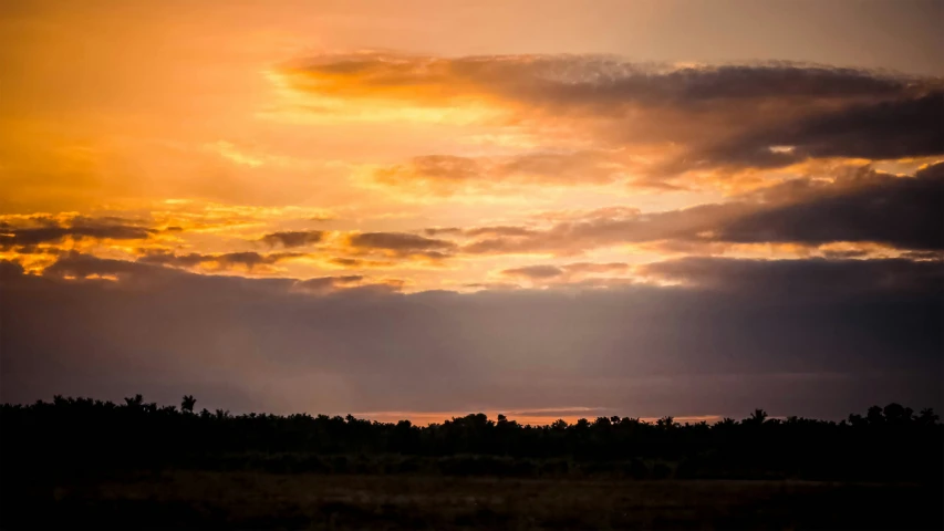 the sky is filled with clouds as the sun sets