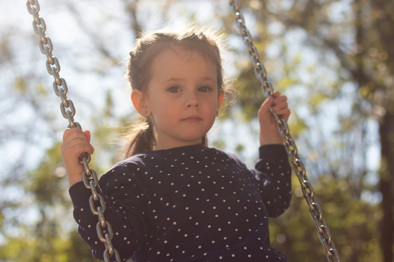 a  sitting on top of a metal swing