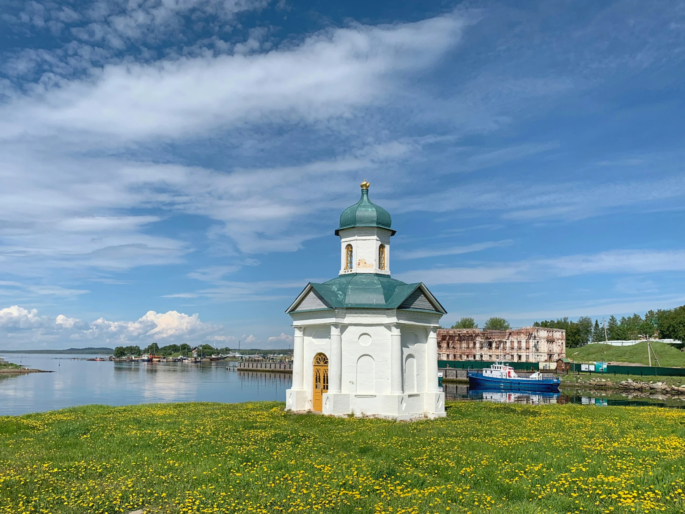 there is a small white clock tower near the water