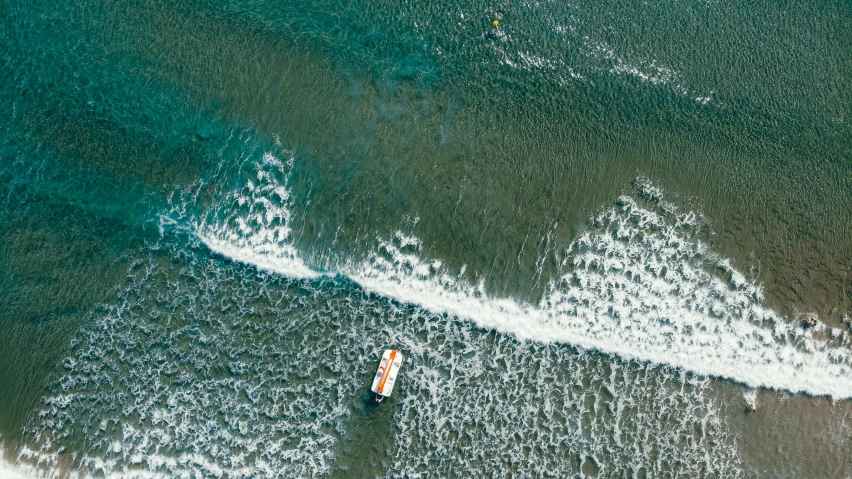 a view from above of a beach with surfers and wave