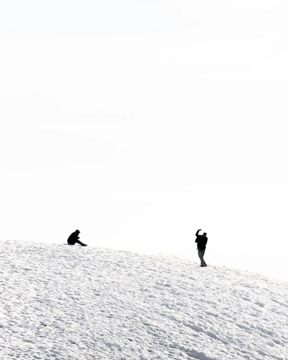 two people standing in the snow while the person is holding their camera up