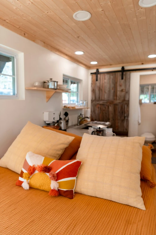 a bed with some brown and yellow pillows