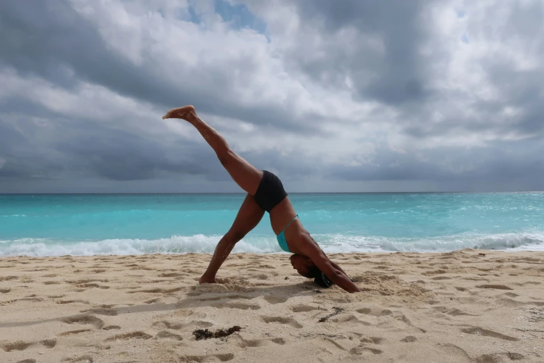 woman on the beach stretching for yoga pose