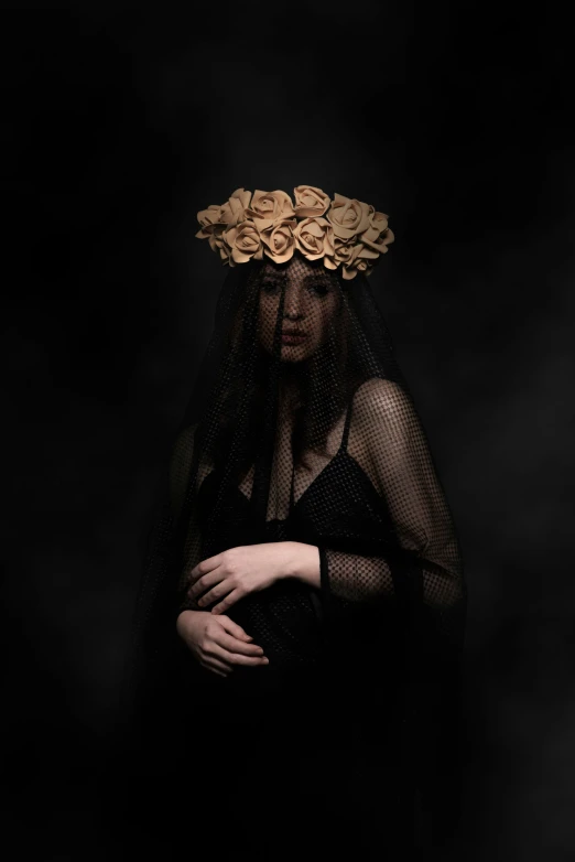 a woman in black wearing a crown of gold flowers
