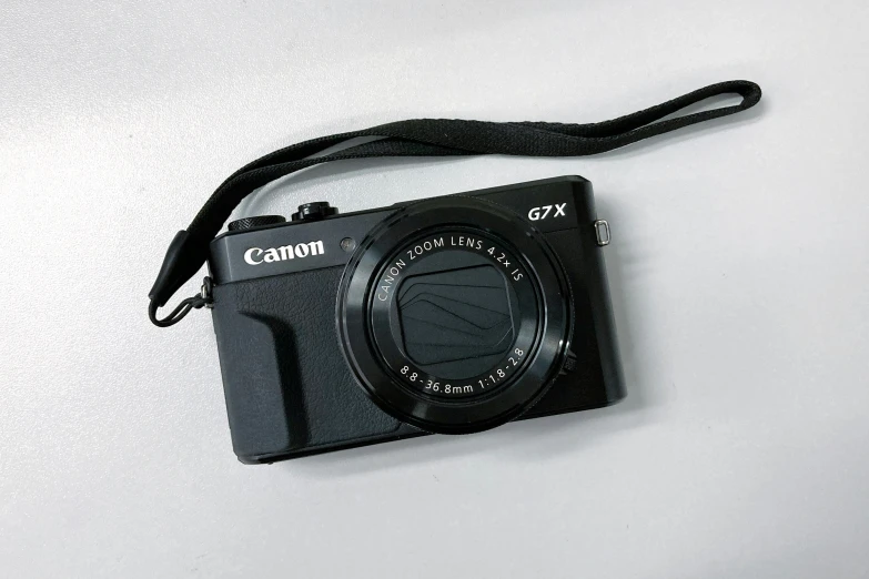 a compact camera sitting on top of a white table