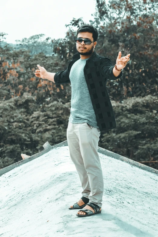 a man standing on the roof of a building with his hands out in an open area