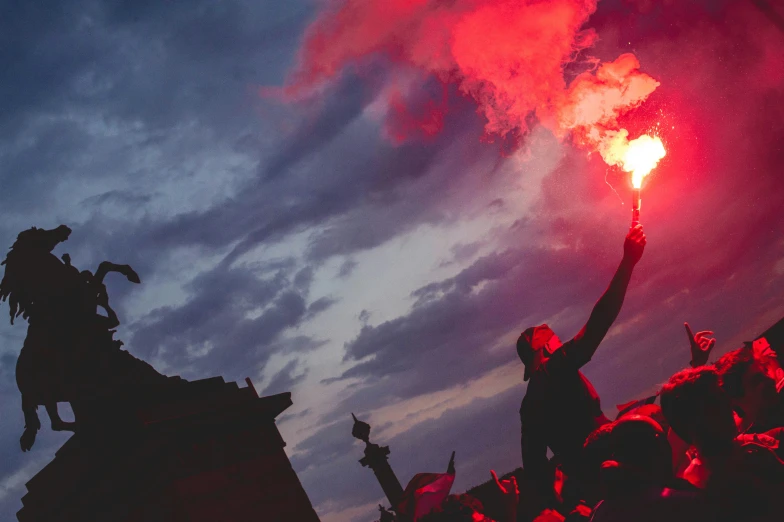 red smoke comes out of the fire as people cheer