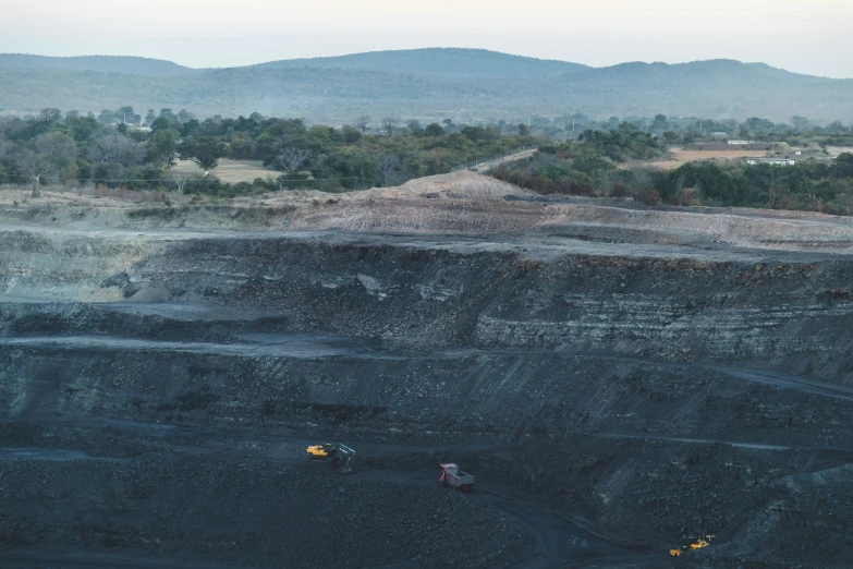 an over head view of a pit with a few trucks going about it